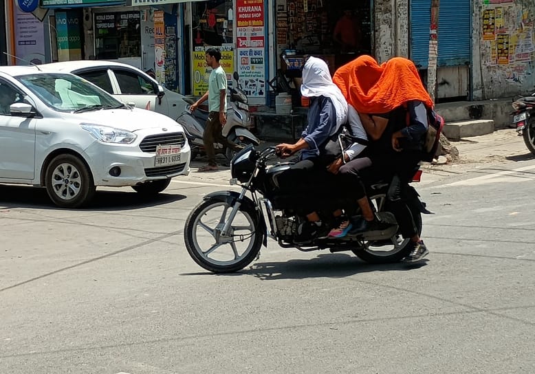 फोटो :37: सोनीपत में गर्मी के बीच सिर पर कपड़ा डालकर जाते बाइक सवार। संवाद फोटो :37: सोनीपत में गर्मी के बीच सिर पर कपड़ा डालकर जाते बाइक सवार। संवाद