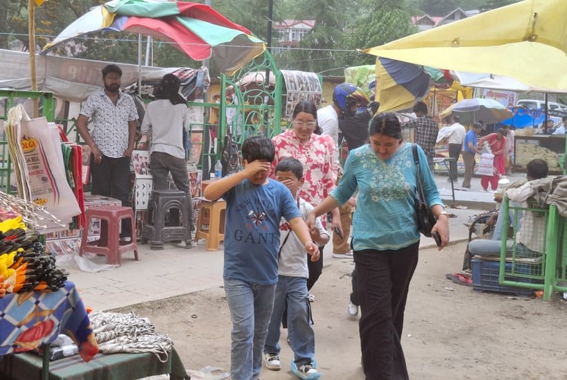 कुल्लू में दिन के समय आई अंधड से उखड़ी त्रिपाल को बाधने में जुटा दुकानदार।-संवाद
