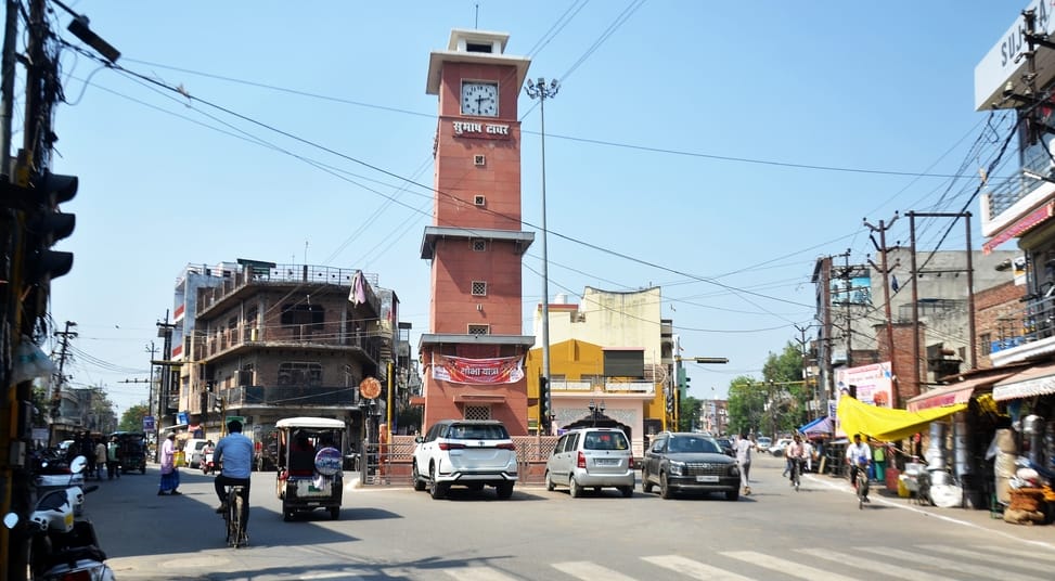 खिरनीबाग चौराहा पर छाता लगाकर तेज धूप का बचाव करते हुए जाते स्कूटी सवार। संवाद