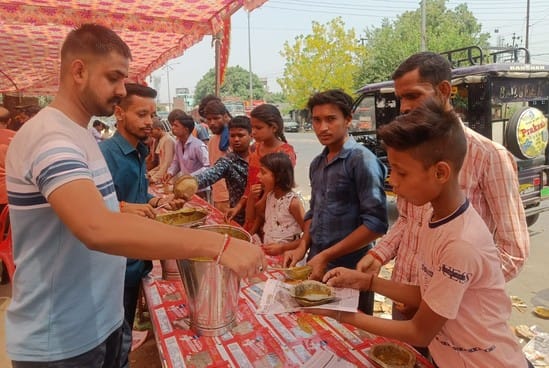 कृष्णा नगर मंदिर के बाहर राहगीरों को शरबत पिलाते सेवादार। संवाद