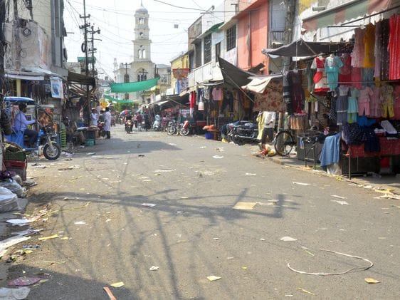 भीषण गर्मी में छाता लगाकर स्टेशन रोड से गुजरती महिला। संवाद