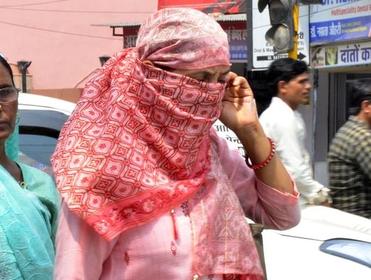 भीषण गर्मी में छाता लगाकर इंद्रा चौक से गुजरती महिला। संवाद भीषण गर्मी में छाता लगाकर इंद्रा चौक से गुजरती महिला। संवाद