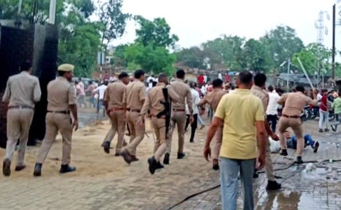भीड़ में से युवक को पकडकर ले जाते पुलिस कर्मी। स्रोत- वीडियो ग्रैब