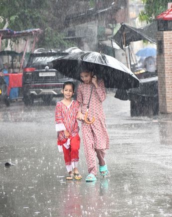 आनंद पुरी में हुए जल भराव के बीच गुजरते लोग।     संवाद