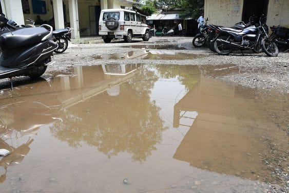 आनंद पुरी में हुए जल भराव के बीच गुजरते लोग।     संवाद