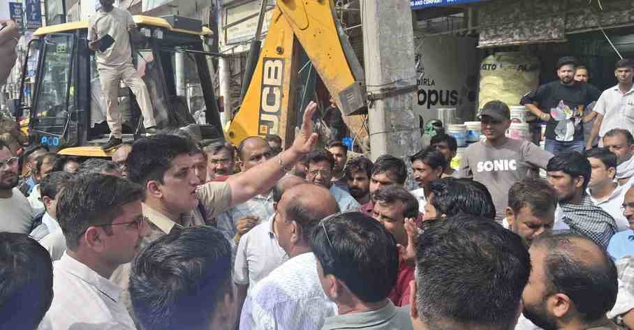 -फोटो 51 : दुकानों के बाहर लगे रोलिंग शेड को जेसीबी से हटाता नप दस्ता। संवाद
