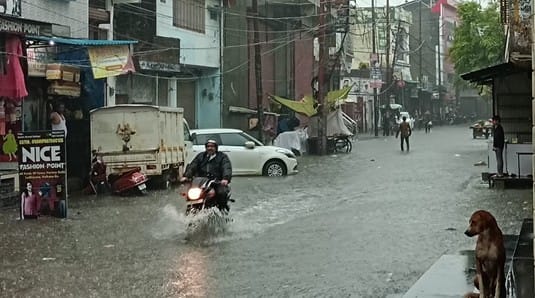 बिजनौर में रविवार की सुबह तेज बारिश से हुए जलभराव से गुजरती कार। संवाद
