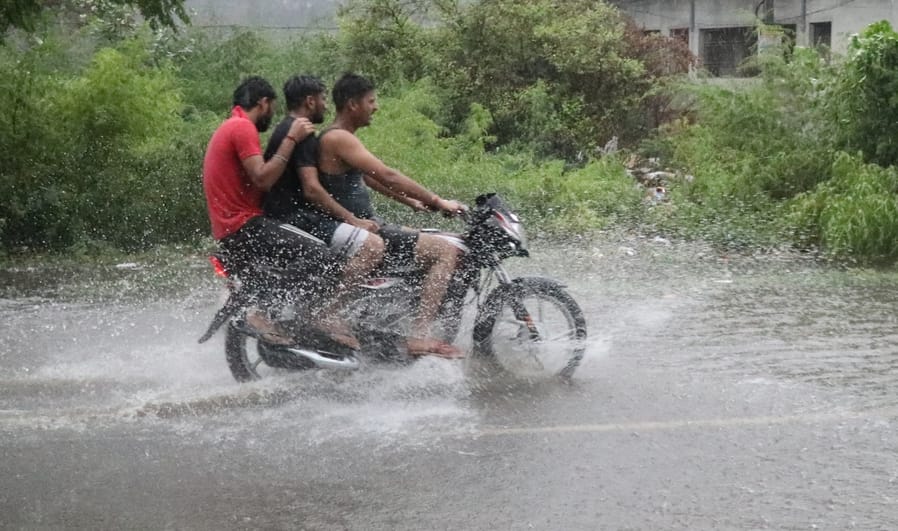 बिजनौर में रविवार की सुबह तेज बारिश से हुए जलभराव से गुजरती कार। संवाद