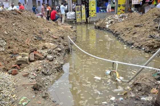 स्टेशन रोड पर दुकान के सामने फैला नाले का मलबा। संवाद