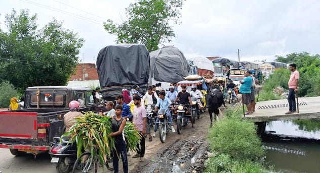 उझानी में कादरचौक रोड पर जाम में वाहनों के बीच फंसे बाइक सवार। संवाद उझानी में कादरचौक रोड पर जाम में वाहनों के बीच फंसे बाइक सवार। संवाद