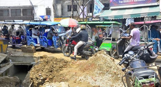 लावेला चौक पर गड्ढे में फंसे वाहन को धक्का लगाती सवारी। संवाद लावेला चौक पर गड्ढे में फंसे वाहन को धक्का लगाती सवारी। संवाद