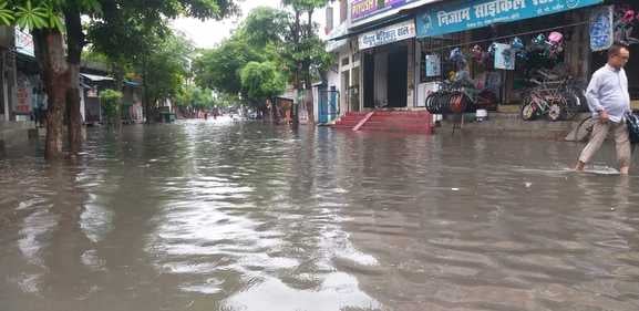 सोमवार को हो रही तेज बारिश में भीगती हुई जाती युवतियां। संवाद
