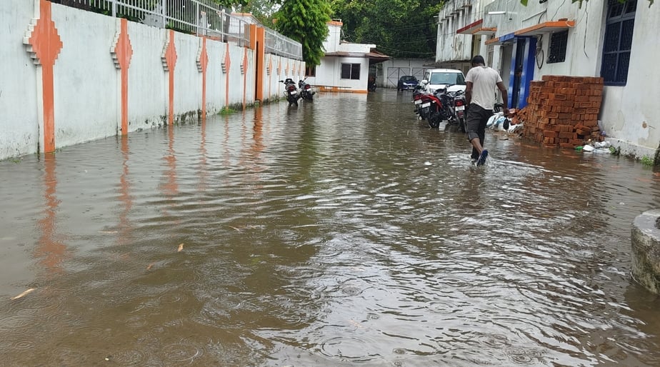 सोमवार को हो रही तेज बारिश में भीगती हुई जाती युवतियां। संवाद
