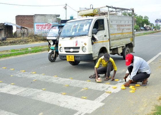 उझानी-बदायूं रोड पर भरे गए गड्ढों पर चलता रोलर। संवाद