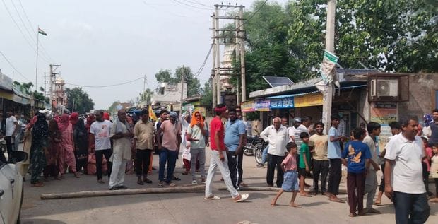 08जेएनडी36: नगूरां गांव में जाम लगा रही महिलाओं को समझाते नगूरां चौकी प्रभारी विनोद कुमार। ग्रा