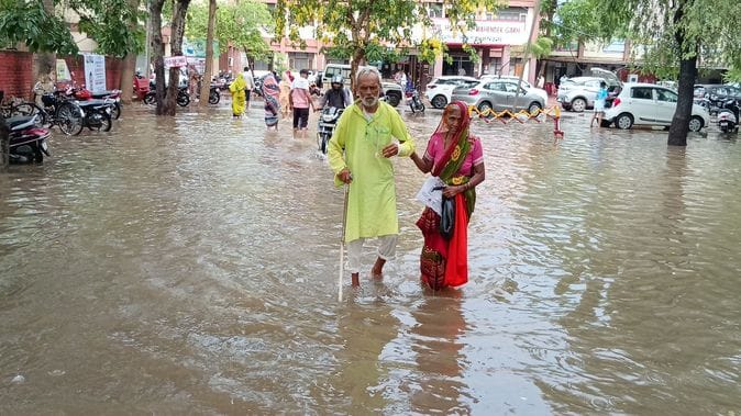 फोटो संख्या:61- बारिश के दौरान गोशाला रोड पर जलभराव होने  से स्कूटी बंद होने से धकेल कर लेकर जा