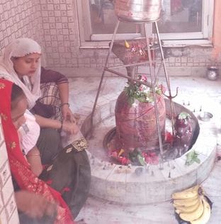 बिरूआबाड़ी मंदिर में भोलेनाथ का जलाभिषेक करते शिव भक्त। संवाद