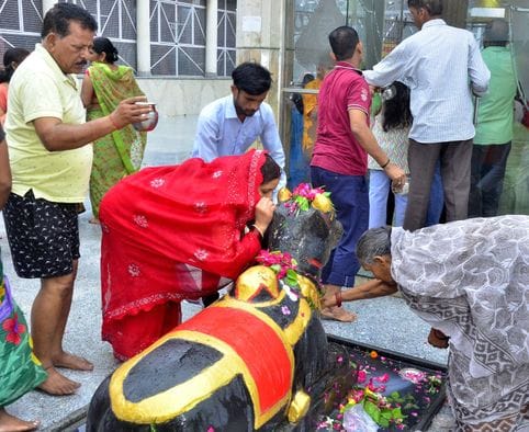 बिरूआबाड़ी मंदिर में भोलेनाथ का जलाभिषेक करते शिव भक्त। संवाद