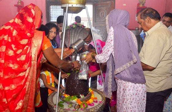 बिरूआबाड़ी मंदिर में भोलेनाथ का जलाभिषेक करते शिव भक्त। संवाद