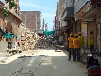 घटनास्थल पर मौजूद अधिकारी व आमजन और मलबा हटाने आई जेसीबी