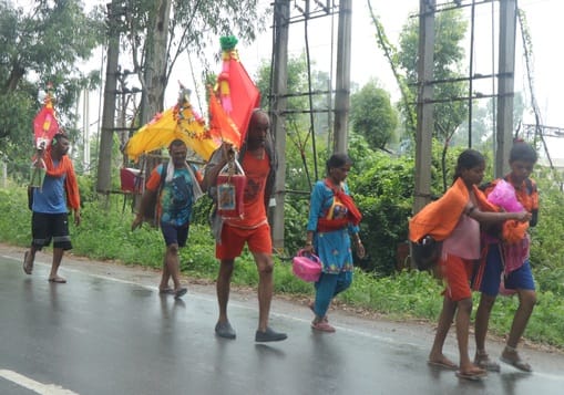 कांवड़ लेकर गुजरते कांवड़िये। संवाद