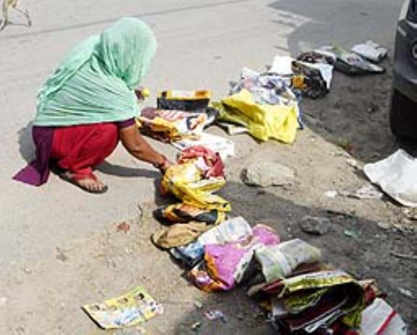 बैग जमीन पर रखकर छांव में खड़े उपभोक्ता।