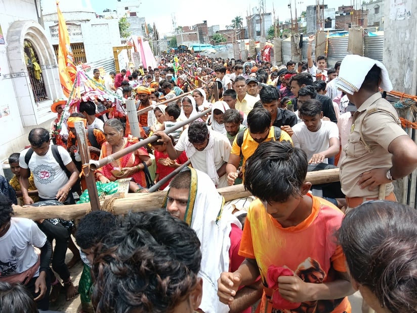 गोला के अशोक चौराहा पर शिव मंदिर के मुख्य मार्ग की बैरिकेटिंग पर रूट डायवर्जन करता पुलिसकर्मी। 