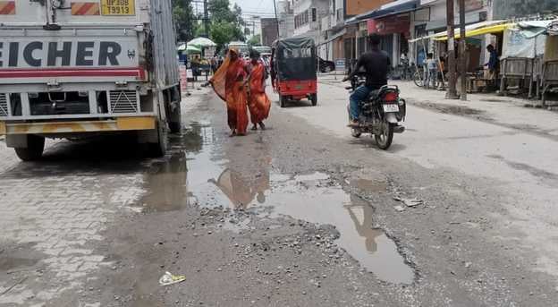 शहर की गढ़ी रोड में गड्ढों से बचकर निकलते वाहन। संवाद
