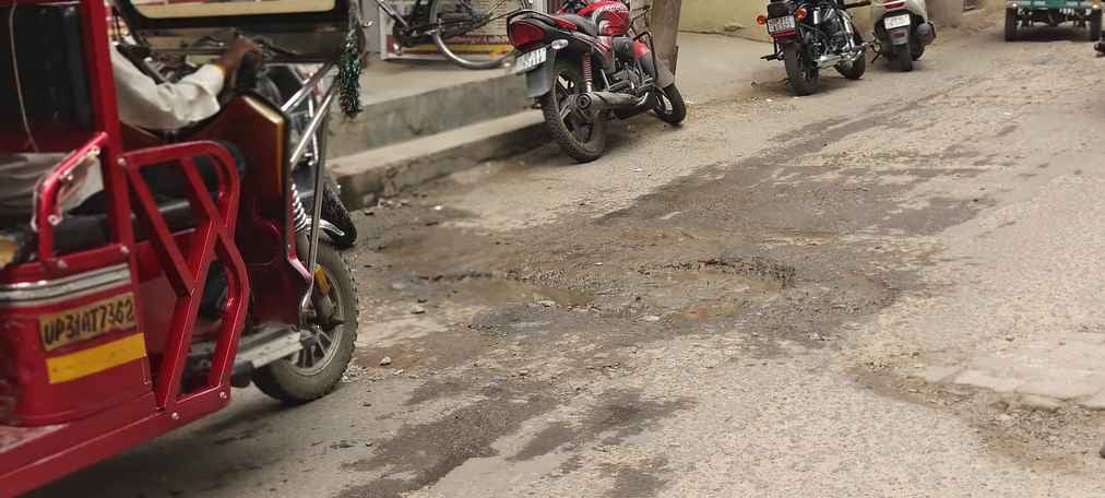 शहर की गढ़ी रोड में गड्ढों से बचकर निकलते वाहन। संवाद