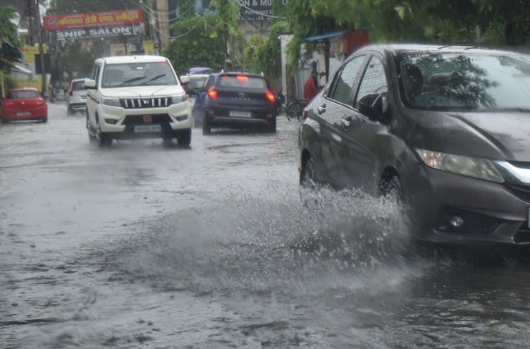 माधवपुरम में बारिश के कई घंटे बाद जर्जर सड़क पर जलभराव और किनारे कूड़े का ढेर
