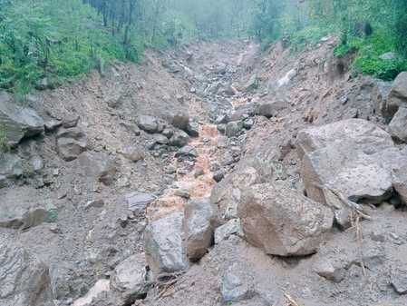 करेरी पंचायत के जंबली में बारिश से गौशाला में दबी बकरी को निकालते हुए व्यक्ति। स्रोत: प्रशासन
