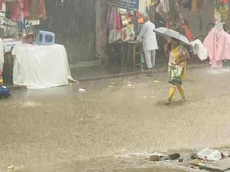 अलापुर में जलभराव के बीच निकलते लोग। संवाद अलापुर में जलभराव के बीच निकलते लोग। संवाद