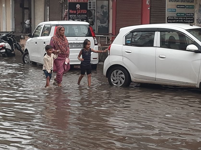 फोटो 28: सोनीपत शहर में हुई बारिश के बाद गीता भवन चौक पर भरे पानी से निकलते वाहन। संवाद