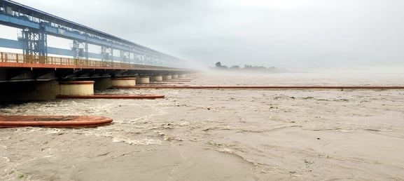 बिजनौर में तेज बारिश में एक छाते के सहारे पूरे परिवार को बचाने का प्रयास करता व्यक्ति। संवाद