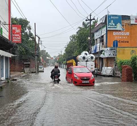 शहर के ड्रमंड कॉलेज मैदान में भरे पानी में खेलते बच्चे संवाद