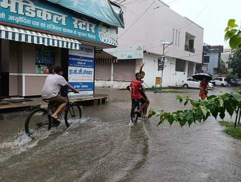 शहर के ड्रमंड कॉलेज मैदान में भरे पानी में खेलते बच्चे संवाद
