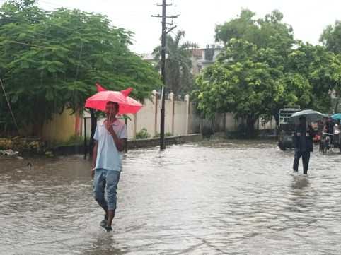 शहर के ड्रमंड कॉलेज मैदान में भरे पानी में खेलते बच्चे संवाद