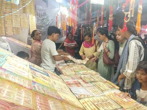 बाजार में एक मिठाई की दुकान पर खरीददारी करते ग्राहक। संवाद बाजार में एक मिठाई की दुकान पर खरीददारी करते ग्राहक। संवाद