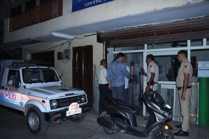 रोहतक में झज्जर रोड पर पुल के नीचे हुई लूट के बाद बिखरे सामान को देखता पुलिसकर्मी। संवाद
