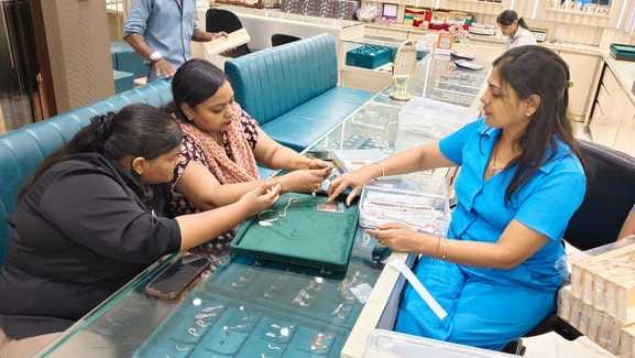 ज्वेलरी शोरूम पर चांदी की राखी पसंद करती महिला। संवाद