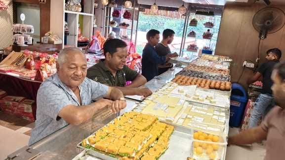 ज्वेलरी शोरूम पर चांदी की राखी पसंद करती महिला। संवाद