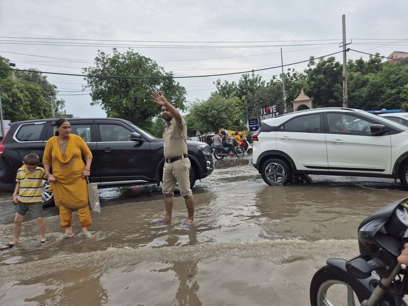 फोटो 34: सोनीपत में हुई झमाझम बारिश के बाद सेक्टर-15 में भरे पानी से गुजरते दोपहिया वाहन चालक। 