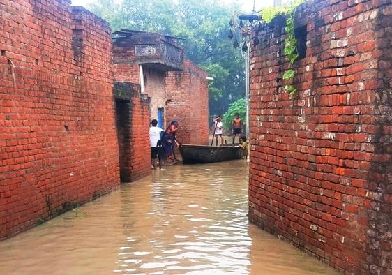 गांव वीरसहाय नगला में भरा पानी , जाते ग्रामीण। संवाद