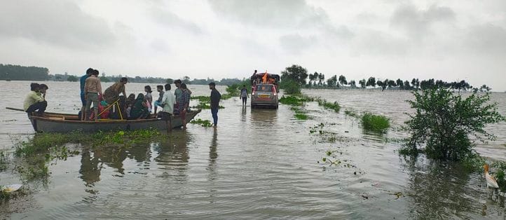 गांव वीरसहाय नगला में भरा पानी , जाते ग्रामीण। संवाद