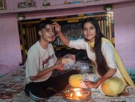 लड़की से राखी बंधवाते समिति अध्यक्ष रतन सिंह रावल। संवाद लड़की से राखी बंधवाते समिति अध्यक्ष रतन सिंह रावल। संवाद