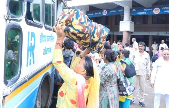 रोहतक से बस अड्डा पर बस में सवार होने के मशक्कत करते यात्री। संवाद