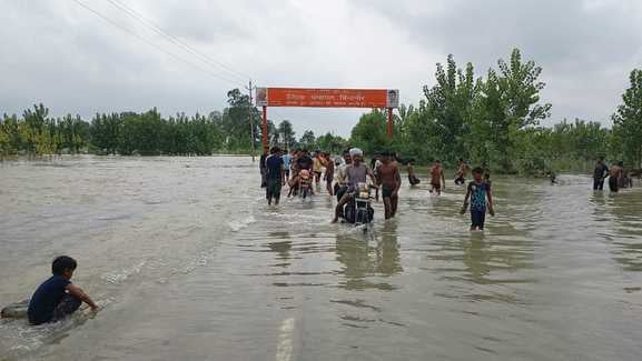 जलीलपुर में बाढ़ के पानी में डगमगाई साइकिल को कंधे पर लादकर ले जाता किसान जलीलपुर में बाढ़ के पानी में डगमगाई साइकिल को कंधे पर लादकर ले जाता किसान