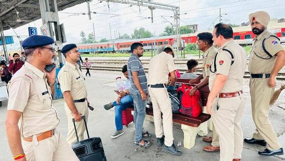 रेलवे स्टेशन पर माइक से लोगों को जागरूक करते सुरक्षाकर्मी। संवाद