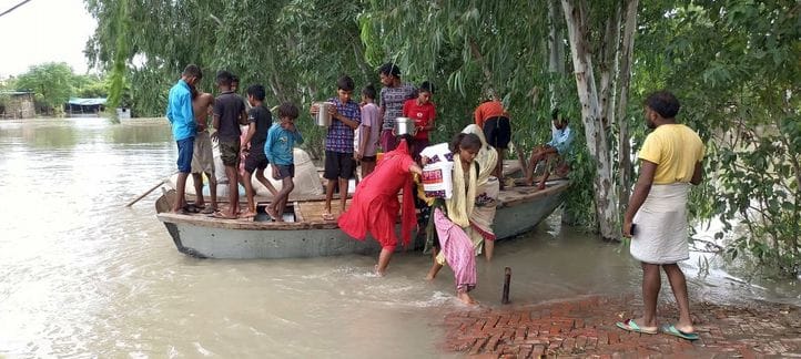 सहसवान के भमरौलिया गांव में नांव से जानवरों का चारा लेकर तटबंध की ओर जाते ग्रामीण। संवाद