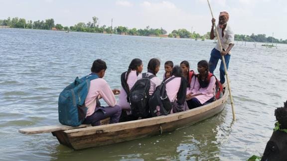 नाव में बैठकर स्कूल जाते बच्चे। नाव में बैठकर स्कूल जाते बच्चे।